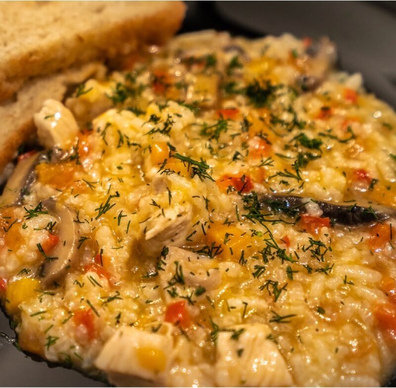 Orez sârbesc cu pui, ciuperci și legume, servit cald în farfurie