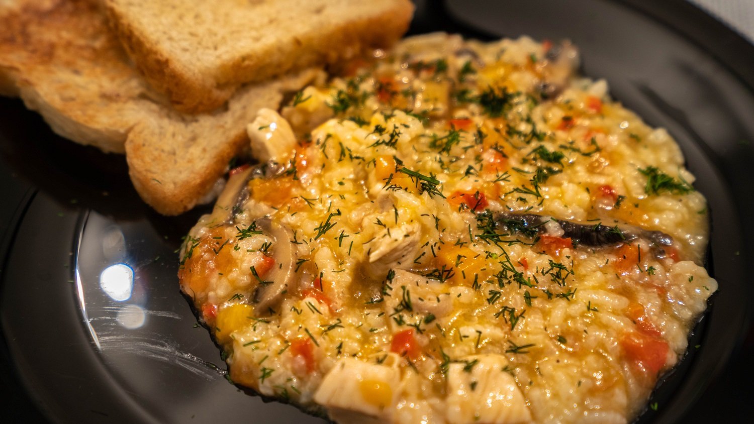 Orez sârbesc cu pui, ciuperci și legume, servit cald în farfurie